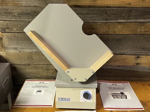 Formax paper jogger on a workbench with its instruction manuals